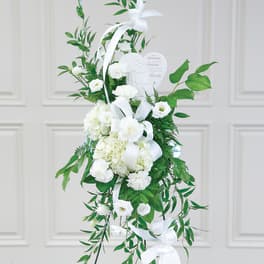 White sympathy standing spray with ribbon and heart plaque