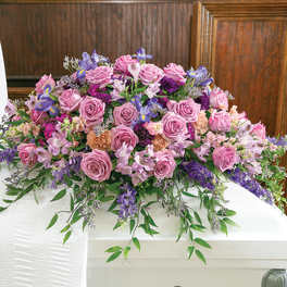 Large pink and purple floral casket spray with roses and lilies