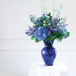 Blue and purple flower arrangement in a cobalt vase