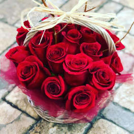 Basket of red roses tied with a cream ribbon