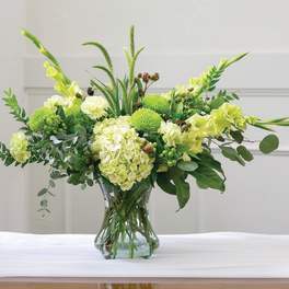 Green floral arrangement in a clear glass vase