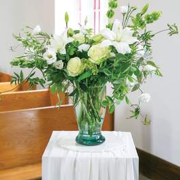 White lilies and pale roses in a glass vase