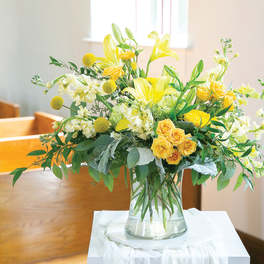 Yellow and white floral arrangement in a clear glass vase
