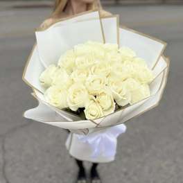 Bouquet of white roses wrapped in white paper with gold trim