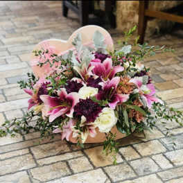 Pink and white floral arrangement in a heart-shaped box
