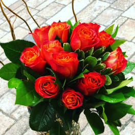 Bouquet of red-orange roses in a mosaic glass vase