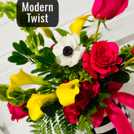 Bouquet of pink roses, yellow calla lilies, and a white anemone in a striped vase