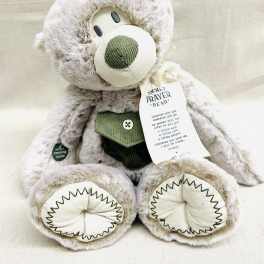 Plush gray teddy bear with a prayer tag and green accents