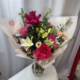 Bouquet of pink and white roses with lilies in a glass vase
