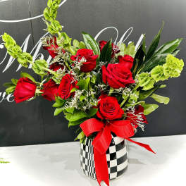 Red roses in a checkered vase with a red ribbon
