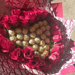 Bouquet of red roses surrounding gold-wrapped chocolates