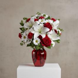 Red roses and white lilies in a red glass vase