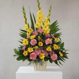 Mixed yellow and pink flowers in a beige vase