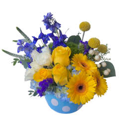 Yellow and white roses with blue flowers in a polka-dot vase