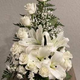 White roses and lilies arranged in a triangular bouquet