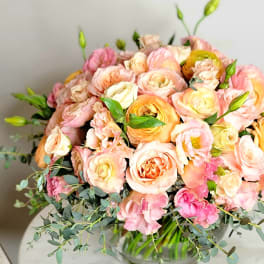 Bouquet of blush and peach roses in a glass vase