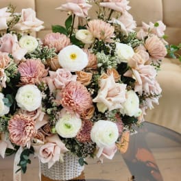 Blush and white bouquet with roses and round blooms in a textured vase