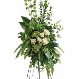 Tall green and white standing arrangement with roses, bells of Ireland, and lush greenery.