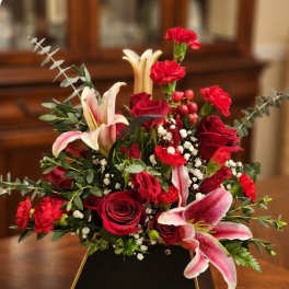 Red roses and pink lilies in a black geometric vase