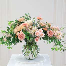 Peach and pink floral arrangement in a clear glass vase
