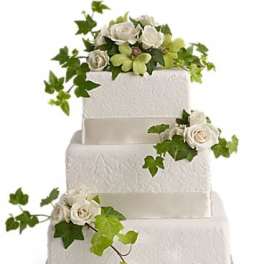 Four-tier white wedding cake with white roses and ivy