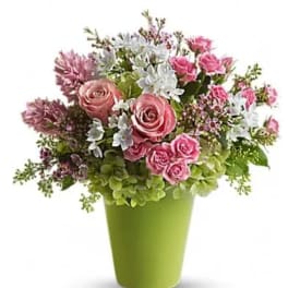 Pink and white mixed flower arrangement in a green vase