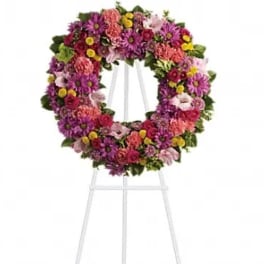 Circular floral wreath on a white easel stand
