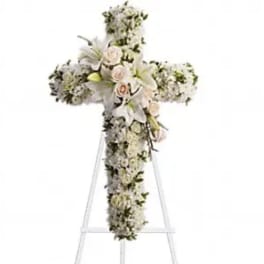 White floral cross arrangement on a standing easel