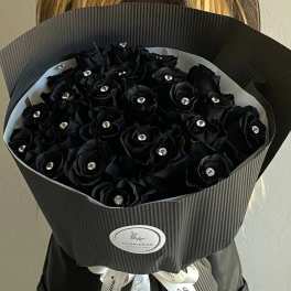 Bouquet of black roses with jeweled centers in dark wrapping