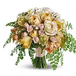 Bouquet of cream and pale pink roses with trailing greenery