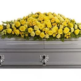Yellow flower spray on a gray casket