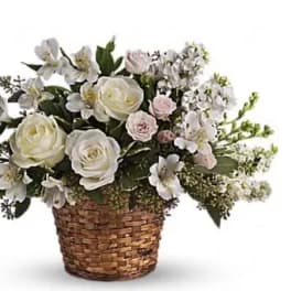 White and pale pink flowers arranged in a woven basket