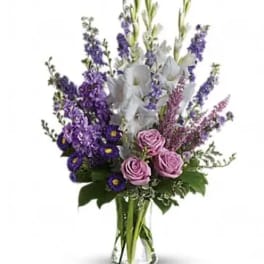 Purple and white mixed bouquet in a clear glass vase