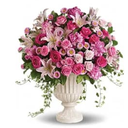 Pink rose and lily arrangement in a white urn vase