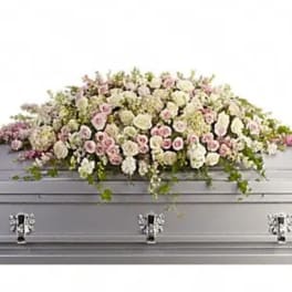 White and pink floral casket spray on a silver casket