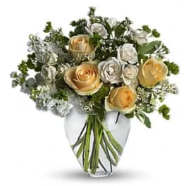 Bouquet of cream and white roses in a clear glass vase