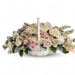Basket arrangement of pink and white roses with a handle