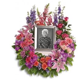 Floral photo tribute wreath with a framed portrait in the center