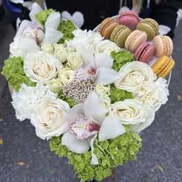 Heart-shaped bouquet with white roses, orchids, and macarons