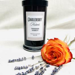 Black candle jar with an orange rose and lavender sprigs