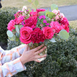 Pink rose and carnation bouquet in a clear glass vase