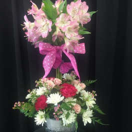 Two-tier floral arrangement with pink lilies and mixed blooms in a metal bucket