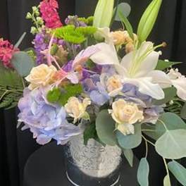 Mixed bouquet with lilies, roses, and hydrangeas in a decorative vase