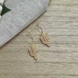 Pair of cactus-shaped hoop earrings on a wood surface