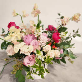 Pink and cream floral arrangement in a white vase