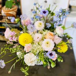 Mixed pastel bouquet with yellow and white blooms in a vase