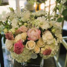 White and blush floral arrangement in a clear vase