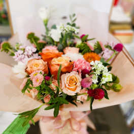 Bouquet of peach and pink roses with mixed small flowers