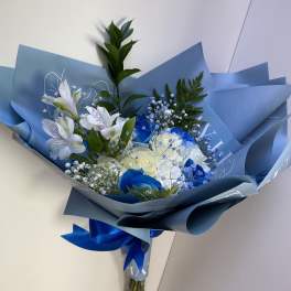 Blue-wrapped bouquet of white and blue flowers with a ribbon