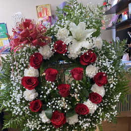Standing floral wreath with red and white roses and a white lily